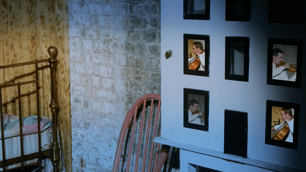 Violinist and cellist perform inside of a doll's house